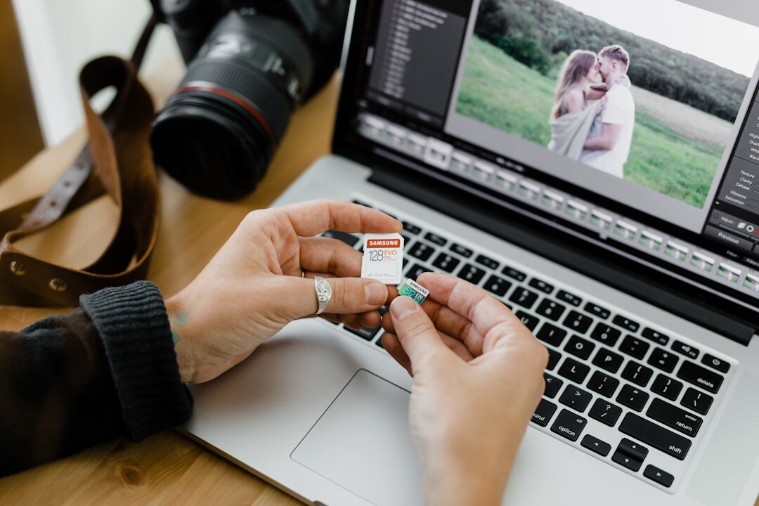 Person editing photos on a laptop with a camera nearby
