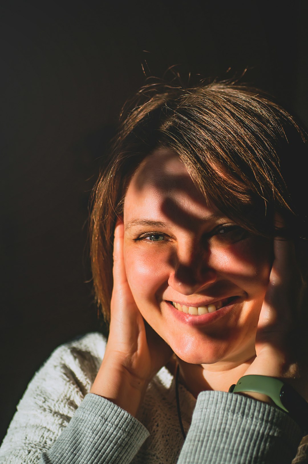 Studio portrait of a woman with short brown hair smiling
